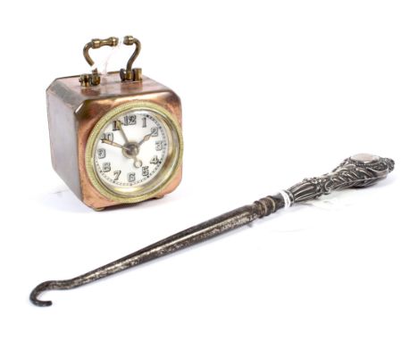 A vintage German D R P &amp; G M travel alarm clock and a silver handled boot hook. The alarm clock with a copper case and br