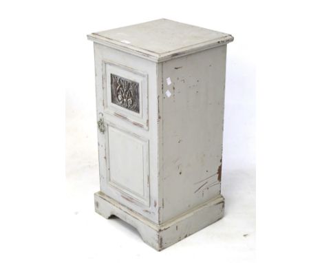 A 19th century mahogany pot cupboard. Painted grey, the panelled door with carved details, opening to reveal a single shelf, 