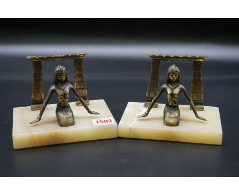 A pair of Art Deco brass and onyx bookends, decorated with Egyptian motifs, 15cm wide.&nbsp; 