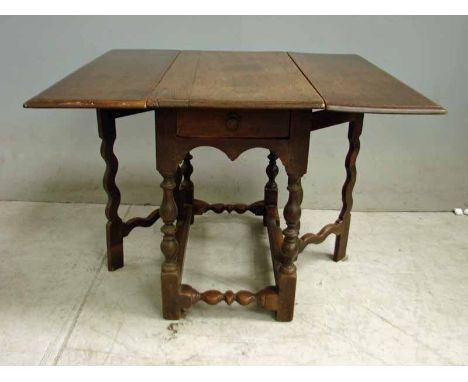 An 18th century oak Joint Drop Leaf Low Table, three part moulded edge rectangular top, single frieze drawer, on turned legs,