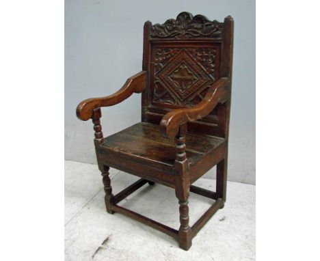 A Jacobean style oak joint Wainscot Armchair, carved crest rail with foliate design, single panel back, carved with diamond d