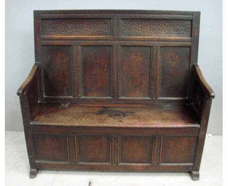 A late18th century oak Box Settle, the rectangular shape back with a pair of carved narrow panels above four plain panels, do