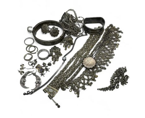 A collection of silver and white metal jewellery. To include a hinged bangle, a locket and rings.