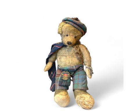 A vintage mohair teddy bear with boot button eyes dressed in Scottish Attire  54cm tall  and in play worn condition. 