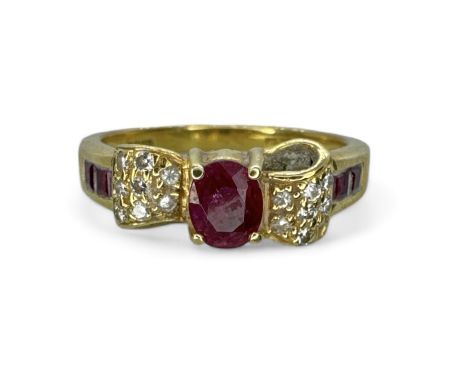 An 18ct gold diamond and ruby set bow ring. Featuring a central 5mm x 4mm oval ruby, at the centre of a pave set diamond bow,