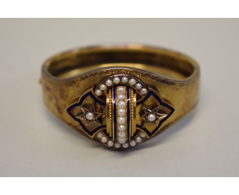 A Victorian gilt metal Etruscan Revival hinged bangle, decorated split pearls and blue enamel. 