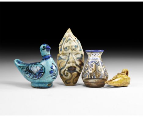 An undated archaistic group of glazed ceramic items including: a pot with frieze of birds and geometric shape; an oil lamp; a