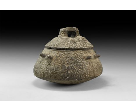 An undated archaistic ceramic bowl, biconvex with rolled rim and four lug handles formed as pairs of ibex-heads, reserved ban