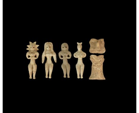 An undated archaistic group of ceramic figurines comprising four nude females each with hands clasped to the midriff and a tw