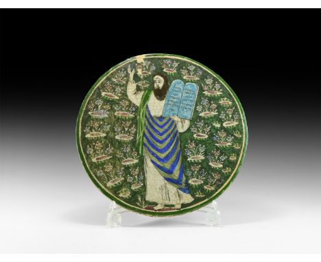 19th-early 20th century AD. A discoid ceramic tile with glaze finish, green field with white border and polychrome flowers, s