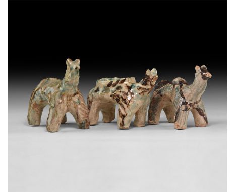 An undated archaistic group of glazed ceramic animals with brown and green texture detailing, one with a scooped dorsal shelf