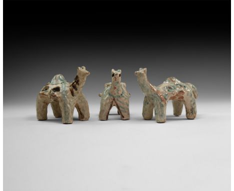 An undated archaistic group of glazed ceramic camels, two with four lateral pinched ledges and the other with a large dorsal 
