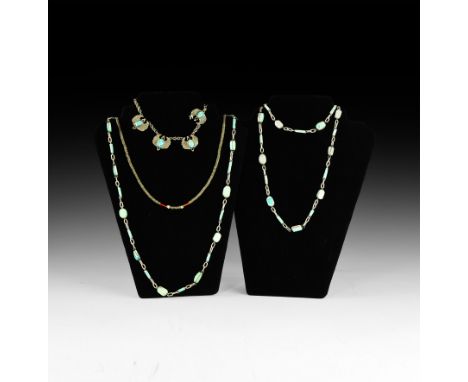 An undated archaistic mixed group of necklaces comprising: two necklaces composed of blue glazed scarabs and tubular beads wi