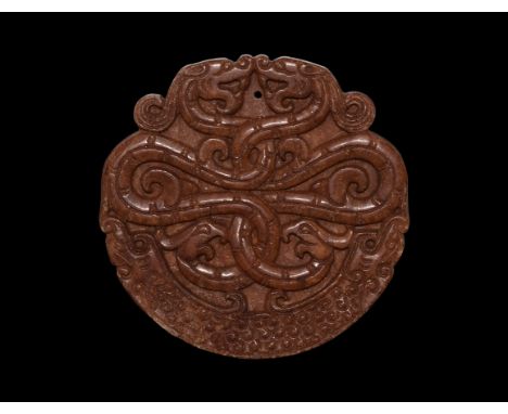 19th-20th century AD. A discoid jade plaque with two facing dragons, with entwined bodies and dragon-headed tails; to the bot