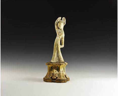 Tang Dynasty, 618-907 AD. A ceramic dancing female figure from the Tang Dynasty on a later wooden stand; figure wearing long 