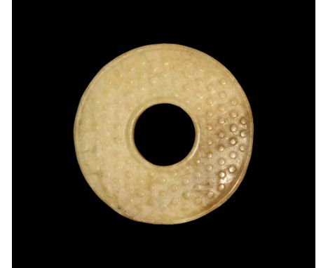 19th-20th century AD. A jade Bi or perforated disc carved on each side with archaistic circular nodes and inner and outer bor