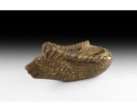 An undated archaistic oil lamp, piriform in plan with ram-head to the apex, horns forming lateral handles, scrolled tendril d