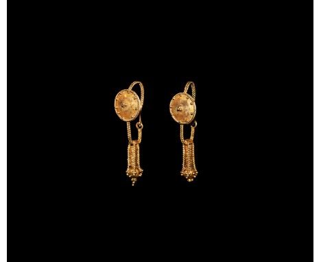 A matched pair of gold undated archaistic earrings, each a ropework hoop with disc, granule detailing and wire to the rim, fi