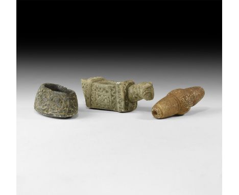 An undated archaistic group of stone items comprising: a tubular bead with median bulb; an oil lamp with scroll ornament; an 