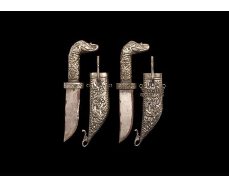 20th century AD. A pair of daggers each in a curved white metal scabbard with sprung clip and suspension chain, with elephant