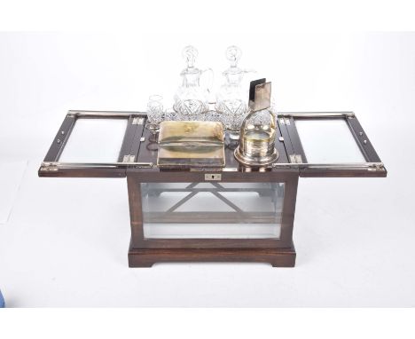 An unusual early 20th Century mahogany and glazed table top drinks cabinetThe two hinged bevelled glass doors with a lifting 