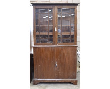 A 20th Century hardwood bookcase cabinetWith a pair of astragal glazed doors enclosing three shelves above two cupboard doors