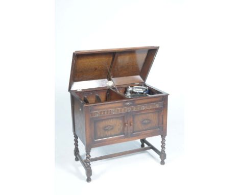 An early 20th Century 'Gilbert' oak cased gramophone cabinetThe hinged rectangular caddy top concealing the turntable and rec