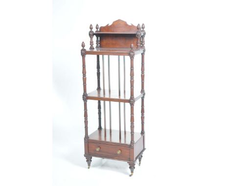 A William IV mahogany whatnot With a shaped pediment, acorn shaped finials over a small shelf and two full shelves each suppo