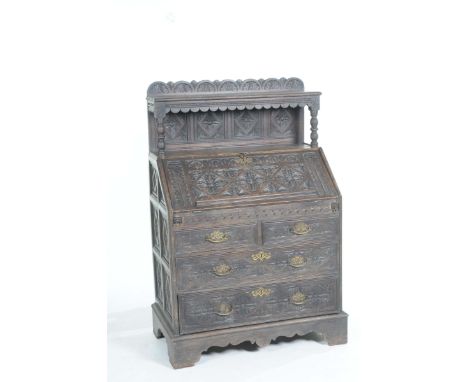 An 18th Century and later carved oak bureau With an architectural raised back comprising a single shelf raised on bobbin turn
