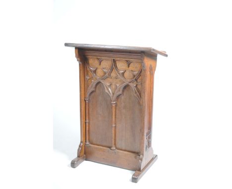 A Victorian Gothic oak lecternThe rectangular angled book rest above a panel applied with C scroll moulding and ring turned c
