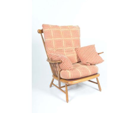 An Ercol medium oak and beechwood arm chairWith a spindle back and outswept arms raised on tapering outswept front and rear l