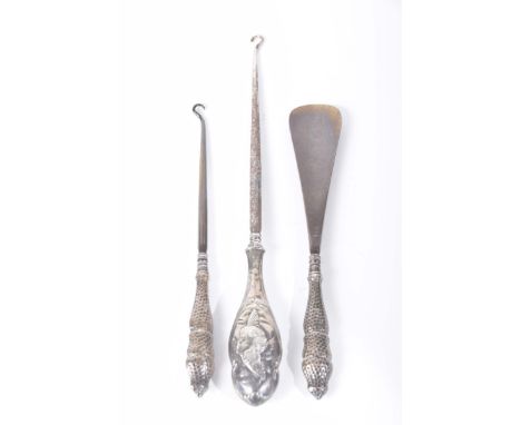An Art Nouveau Chester hallmark silver handled button hook decorated with Cherub masks, marks rubbedTogether with a pair of A