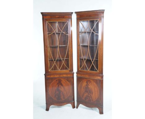 A pair of good quality Reprodux mahogany freestanding corner display cabinetsEach with crossbanded moulded cornice above a cr