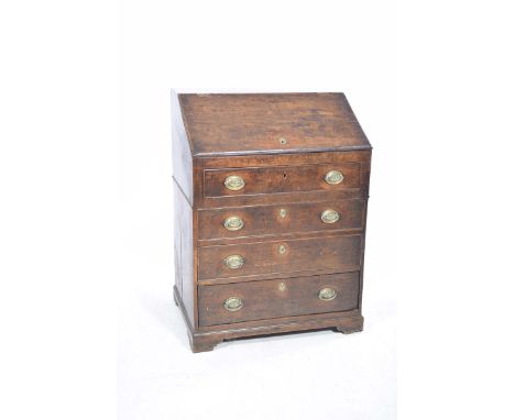 An 18th Century oak bureauThe hinged sloping fall front enclosing drawers and pigeon holes, above four graduated long drawers