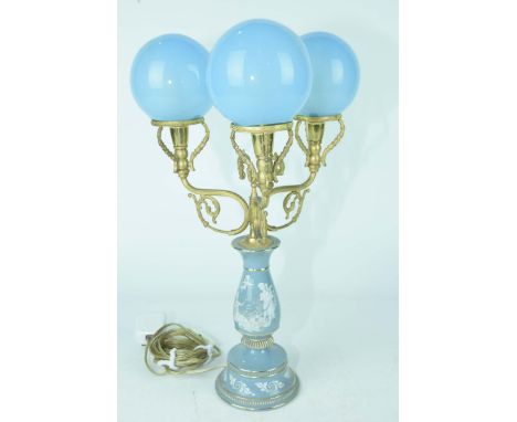 A blue ceramic and gilt metal three branch table lamp, mid 20th CenturyThe 48cm high light fitting with blue glass globe shad