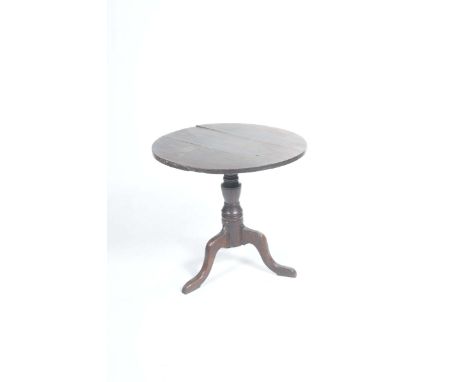 A Georgian country oak tripod tableWith a circular top supported on a ring turned baluster shaft with three down swept suppor