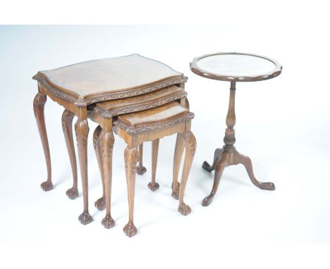 A nest of three bur walnut tea tables and a mahogany wine tableThe tea tables with a shaped glass inset top above a carved bo