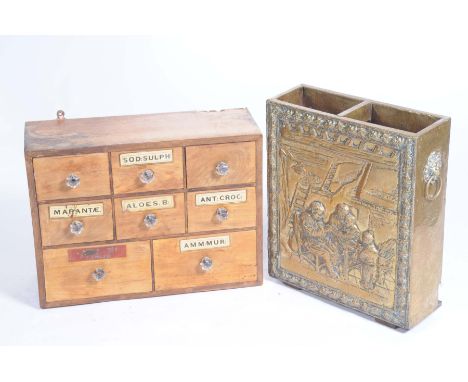 An early 20th Century oak apothecary's chest and an embossed brass stick stand The apothecary chest with an arrangement of ei