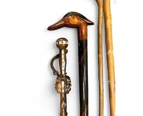 A range of walking sticks to include a stick with mother of pearl inlay and carved double African head, and a duck head walki