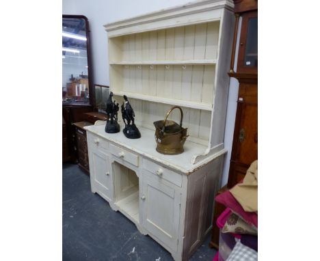 A CREAM PAINTED PINE DRESSER, THE ENCLOSED TWO SHELF BACK ABOVE A BASE WITH THREE DRAWERS OVER TWO CUPBOARDS FLANKING A NICHE