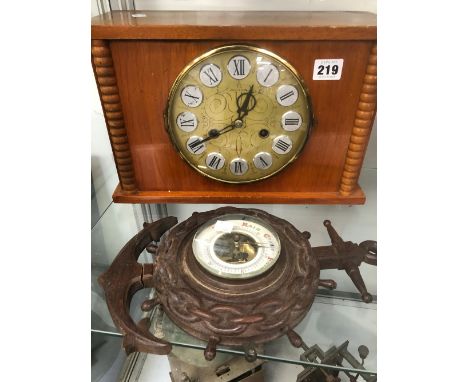 A CARVED OAK BAROMETER AND A MANTEL CLOCK. 