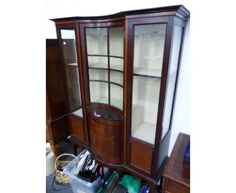 AN EDWARDIAN MARQUETRIED MAHOGANY DISPLAY CABINET WITH GLASS PANELS FLANKING THE INCURVED DOOR ABOVE A BOW FRONT SHELF AND CU