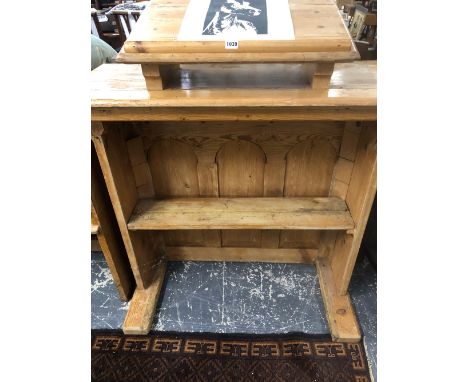 A VICTORIAN PINE LECTERN, THE BOOK REST ABOVE A SHELF AND THE ENCLOSED FRONT ON PLANK FEET.   W 103 x D 41 x H 113cms.