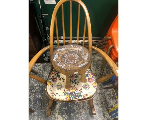 AN ERCOL STICK BACK ROCKING CHAIR TOGETHER WITH AN AFRICAN STOOL, THE SEAT WITH BEADED GIRAFFE AND BIRD DECORATION