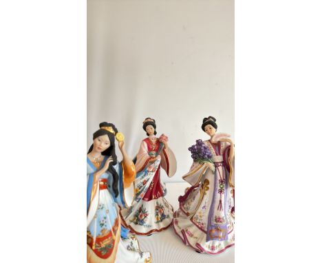 Three porcelain figurines, produced by the Danbury Mint, MBI. Each figure holds flowers or a fan.