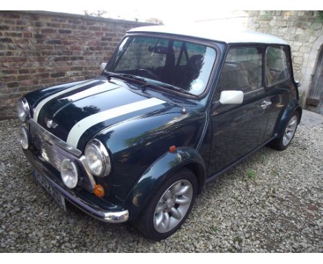 A 1991 Rover Mini Cooper, registration number H352 DDL, British Racing green with a white roof. This Mini Cooper has been mod