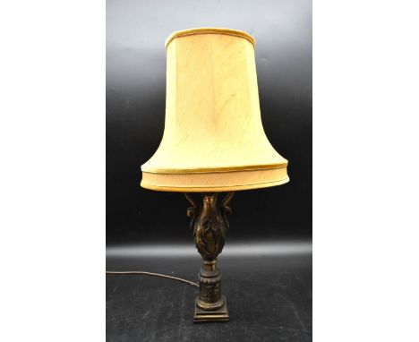 A brass baluster lamp with embossed Oriental male and female figural decoration and rope style handles along with a cream sha