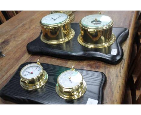 TWO REPRODUCTION CLOCK AND BAROMETER SETS 
each mounted on an ebonised wood 