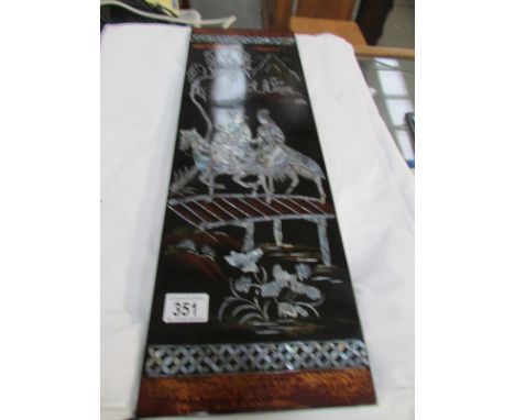 A lacquered panel inlaid with mother of pearl.