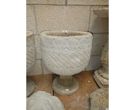A Mayan circular planter with Aztec design.
